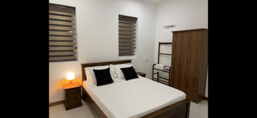 卡图纳耶克Silina Airport Residence的卧室配有白色床、床头柜和台灯。