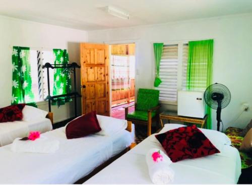 阿皮亚阿坡拉高地休息室宿加早餐旅馆的客厅配有2张白色的床和绿色窗帘