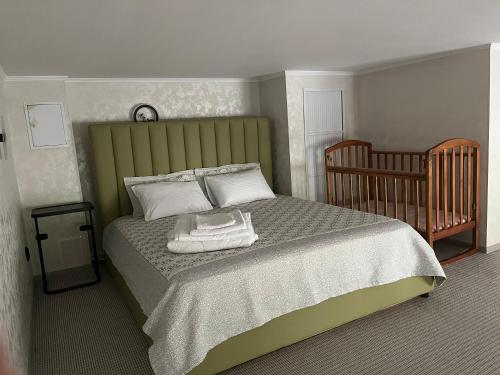 博罗沃耶Современные и уютные аппартаменты的一间卧室配有一张床和一张婴儿床。
