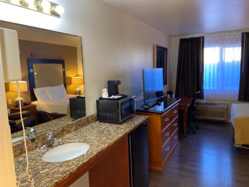 ToppenishToppenish Inn and Suites的酒店客房设有带床和水槽的浴室