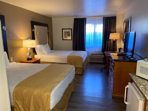 ToppenishToppenish Inn and Suites的酒店客房设有两张床和一台平面电视。