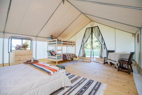 CassvilleRoaring River Luxury Glamping #4的帐篷内的卧室,配有一张床和一张书桌