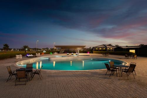 阿可贺巴HDB Al Khobar Resort & Spa的游泳池前设有桌椅