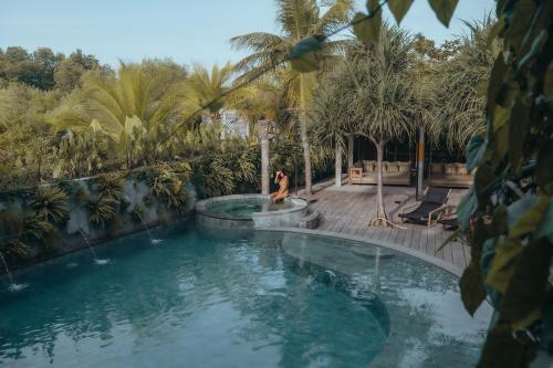 班尤温当Mangroove Bay Boutique Hostel的一位女士站在游泳池旁边