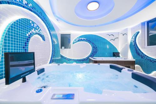 奥布罗瓦茨Hotel Kanjon Zrmanje的蓝色瓷砖的客房内的浴缸