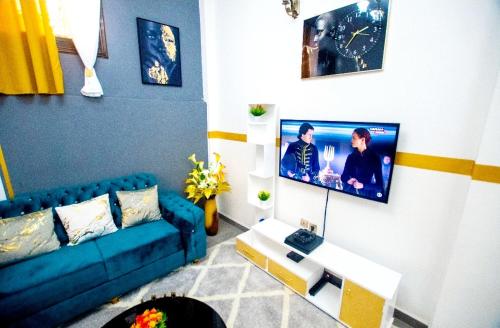 杜阿拉Appartement meublé的客厅配有蓝色的沙发和电视