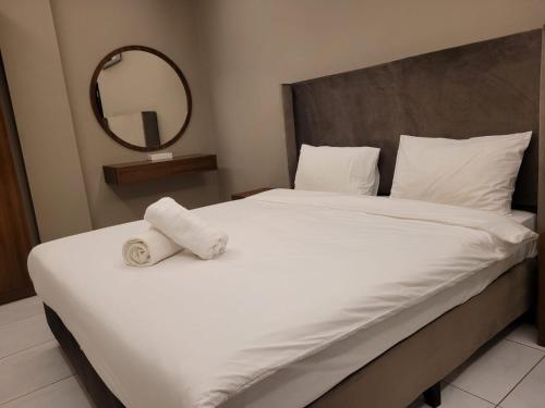 塞拉莱Salalah Beach Villas的卧室配有一张带镜子的白色大床