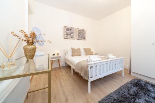 伦敦Kensington luxury flat with patio的白色卧室配有床和玻璃桌