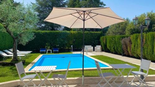 Rocchetta a Volturno索金特住宿加早餐旅馆的游泳池配有遮阳伞、2把椅子、桌子和遮阳伞