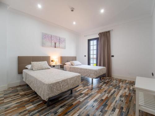 圣克鲁斯-德特内里费Balcón de Costanera的酒店客房设有两张床和一张桌子。