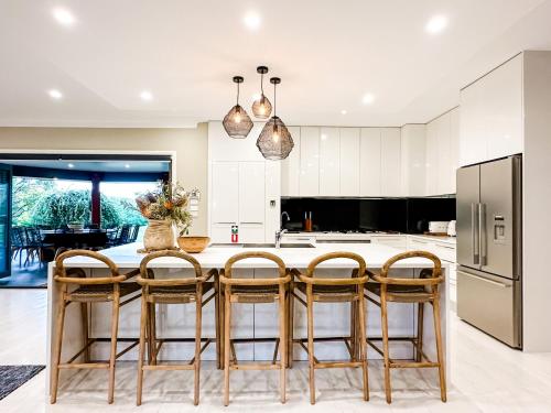 金德拜恩Hamilton House - Snowy Mountain Luxury Villas的厨房配有桌椅和冰箱。