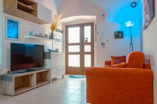 Le MarmoreCasa Vacanze Le Cascate的一间带电视和橙色椅子的客厅