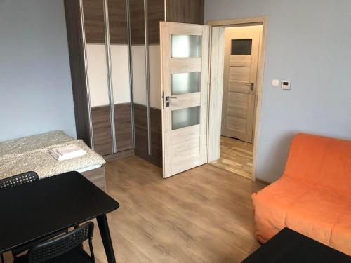 比得哥什Apartament Zwirki i Wigury 38的小房间设有橙色的沙发和门