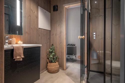 斯特兰达Premium Penthouse near Strandafjellet Ski Resort & Geiranger - Panoramic Mountain Views & Sauna的浴室设有水槽和带圣诞树的淋浴。