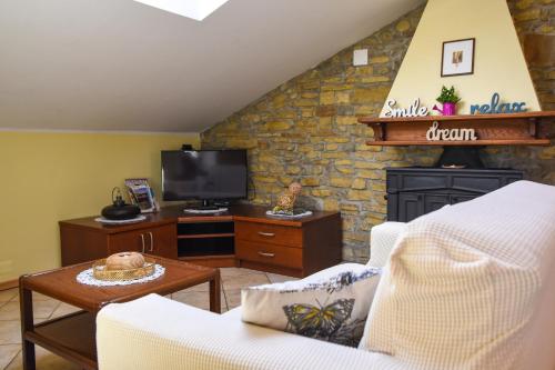 格罗日年Apartman Villa Romana的客厅设有壁炉和电视。