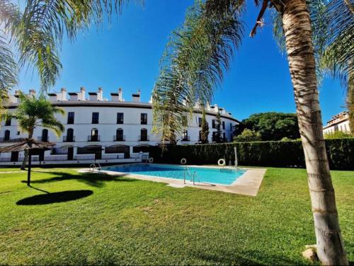 贝莱斯德韦瑙达利亚La Bicicleta, Duplex en Vélez Benaudalla的一座带游泳池和棕榈树的房子