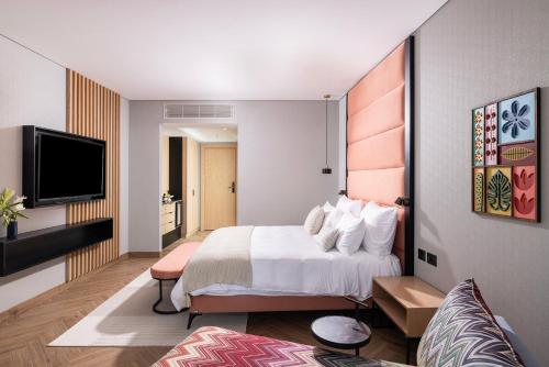 内韦伊兰Almond Hotel - Adults only的配有一张床和一台平面电视的酒店客房