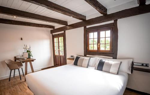 宏达瑞比亚阿洛特森尼亚乡村旅馆的卧室配有一张白色的大床和一张桌子