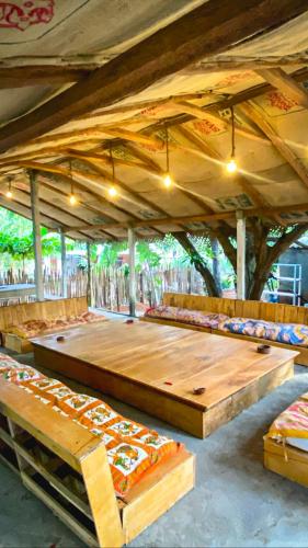 亭可马里Laughing Leopard Trinco的帐篷下配有长凳的大型木桌