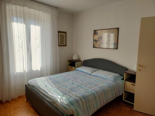 罗韦雷托Appartamento Gisella的一间卧室设有一张床和一个大窗户