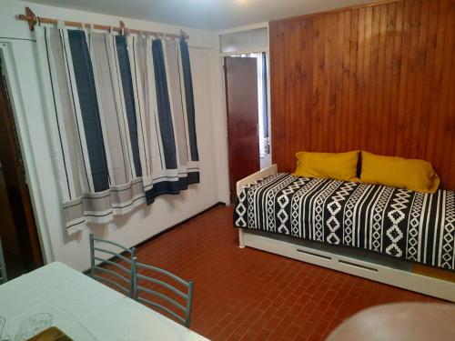 门多萨CONSORCIO ARIZU的卧室配有床、桌子和窗户。