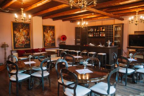 帕莱斯潘蒂雷蒙Pliades Traditional Guesthouse的一间带桌椅的餐厅和一间酒吧