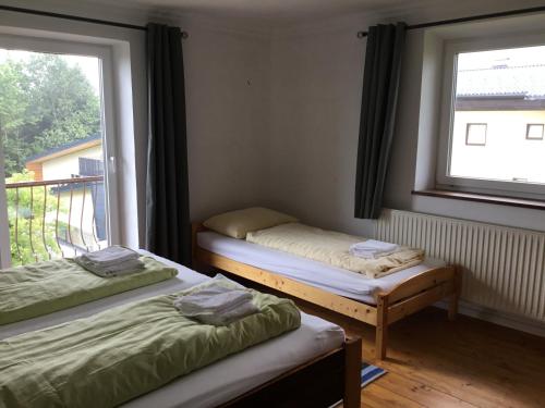 马特塞Haus Schmid Mattsee的带窗户的客房内设有两张单人床。