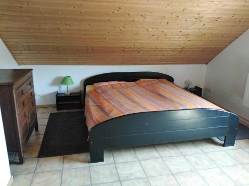 SeibersbachGästehaus Silbersbach的一间卧室设有一张床和木制天花板