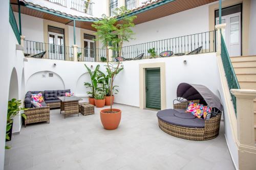 法鲁Guest House Jacarandá Faro的户外庭院设有柳条家具和植物