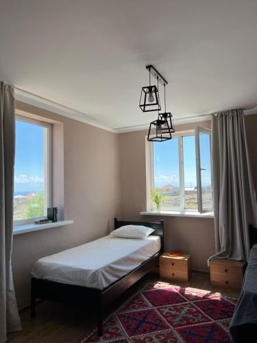 乔尔蓬阿塔Guest house Hygge的一间卧室设有一张床和两个窗户。