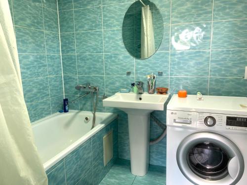 博孔巴耶沃Guest house Ayperi的浴室配有洗衣机、水槽和洗衣机。