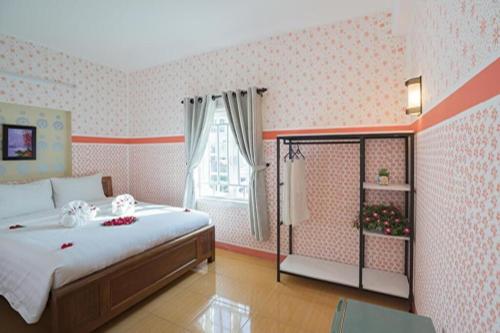 会安Cua Dai Beach Homestay的一间卧室设有一张大床和一个窗户。