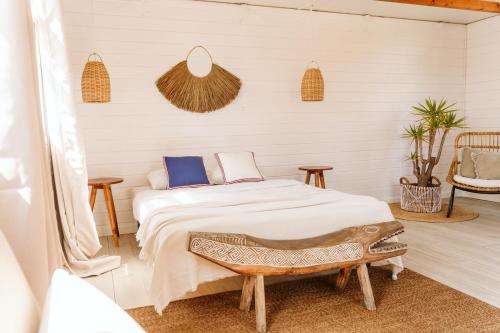 科武港Dreamsea Bungalows Alentejo的一间卧室配有一张床和两张桌子