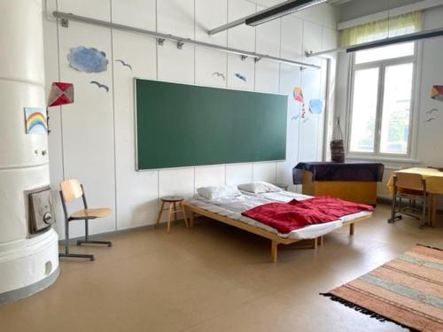 库奥皮奥Retkeilymaja Virkkula的一间设有一张床和墙上屏幕的房间