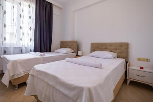 贝莱克ASSOS APART BELEK的一间卧室设有两张带白色床单的床和窗户。