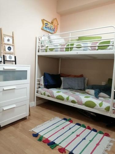 里贝拉Rías Baixas. Acogedor piso en la Ría de Arousa的儿童卧室配有两张双层床和地毯