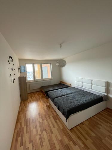 布拉格Apartment 153 - Rezidence Eliska - Prague 9的卧室配有一张床,墙上挂着一个钟