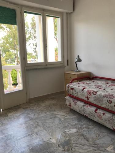 里奥马里纳Isola d'Elba casa vacanze - Villa Portello - la casina bis - quarzo-pirite的一间卧室设有一张床和两个窗户。