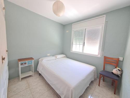 托里代巴拉Torredembarra House的卧室配有床、椅子和窗户。