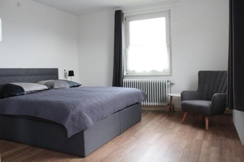瓦尔茨胡特田根Ferienhaus Waldshut-Tiengen 2-10 Personen的卧室配有床、椅子和窗户。