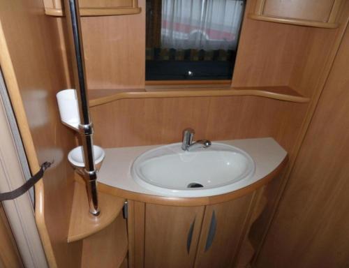 艾瓦耶Olga caravane的一间带水槽的浴室和一个位于走廊的窗户