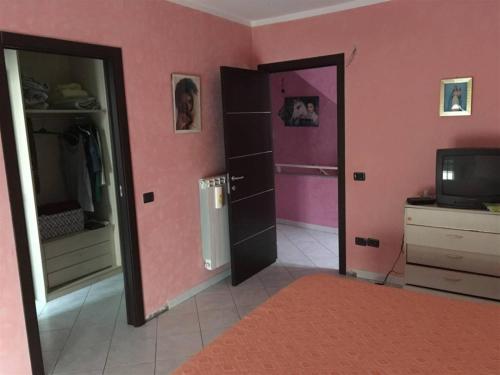 VallefioritaLa Piccola Valle的粉红色的房间,设有两个开放式的门和电视