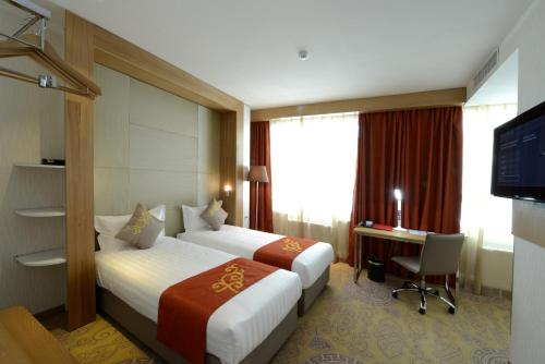 乌兰巴托乌兰巴托九酒店的酒店客房设有两张床、一张桌子和一台电视。