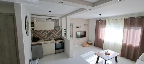 西洛卡特伦Xylokastro cozy apartment的带小桌子的厨房和带窗户的厨房