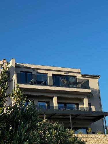 普利莫顿Miliša residence的公寓大楼的背景是蓝色的天空