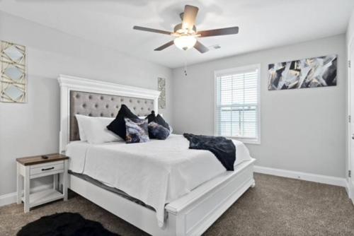 克拉克斯维尔Stay Happy的卧室配有白色的床和吊扇