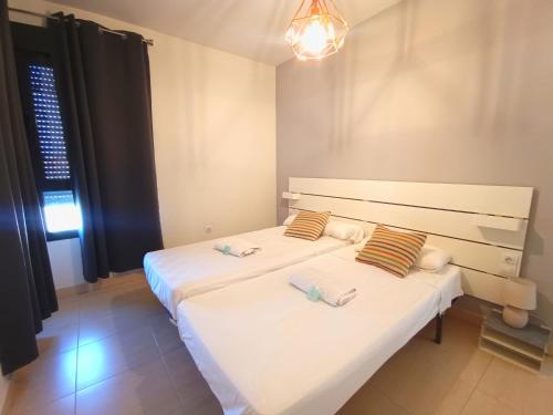 滨海罗克塔斯Expoholidays - Apartamento Auditorio Roquetas的一间卧室配有两张带毛巾的床