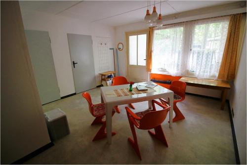 德兰斯克DDR Bungalow direkt am Strand auf Rügen的一间带桌子和红色椅子的用餐室