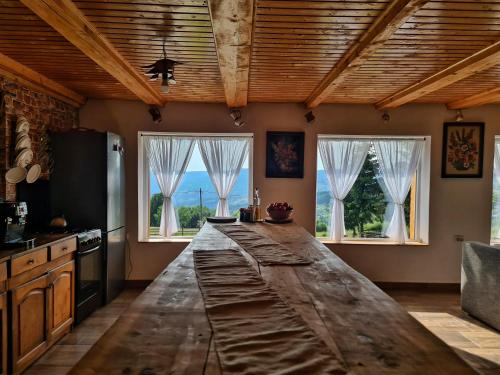 肯佩尼Cabana Dor de Apuseni的厨房配有2扇窗户前的大型木制台面