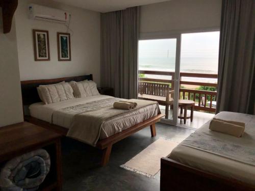 佩尼亚Pousada Casa Albatross的一间卧室配有一张床,享有海景